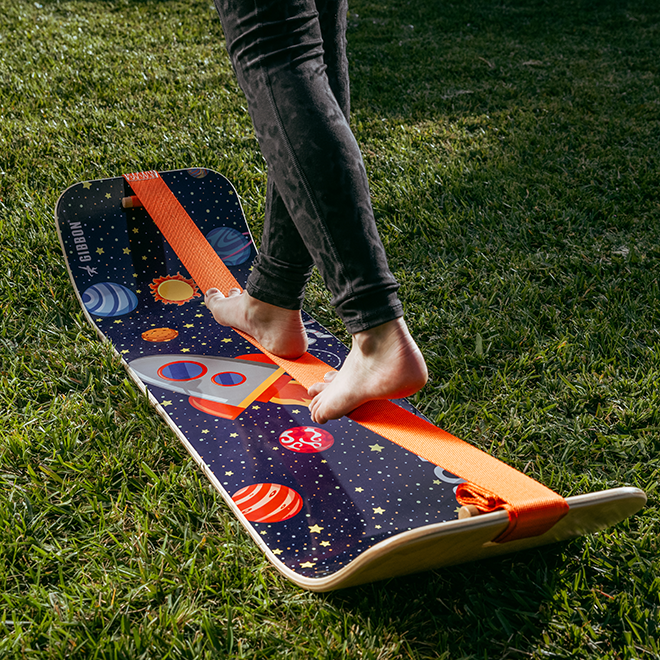 Person stepping onto an astro slackboard on grass
