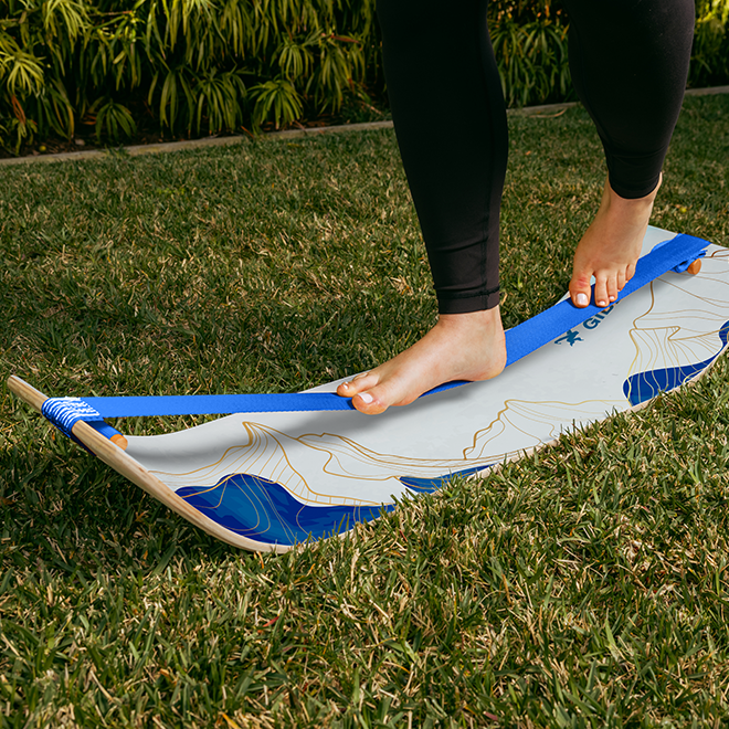 Person balancing on a Mountain Slackboard over grass