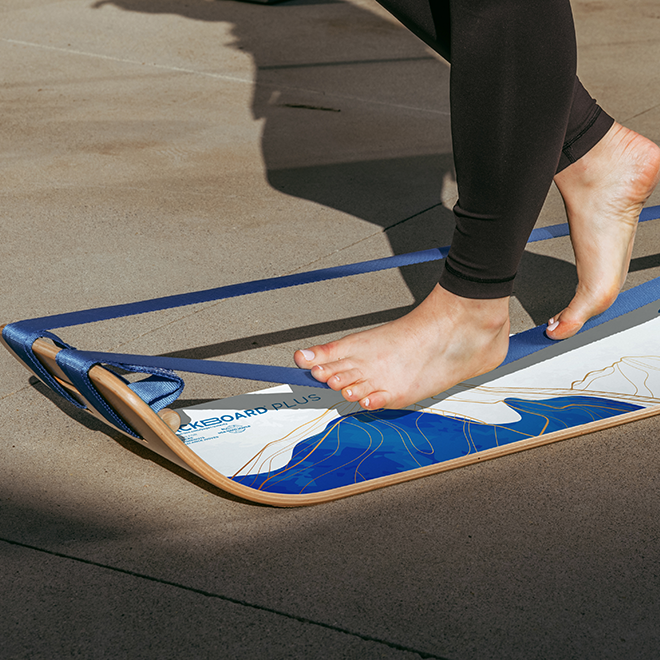 Person stepping onto a mountain slackboard plus on a concrete surface.