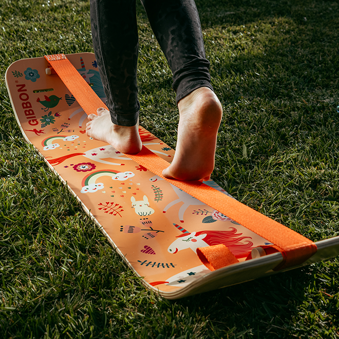 Person stepping onto a unicorn slackboard on grass