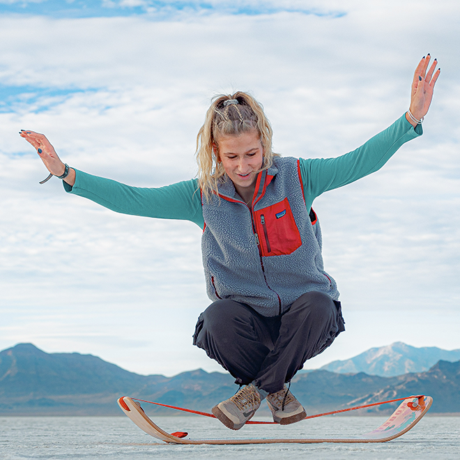 Person balancing on a slackboard with mountains in the background